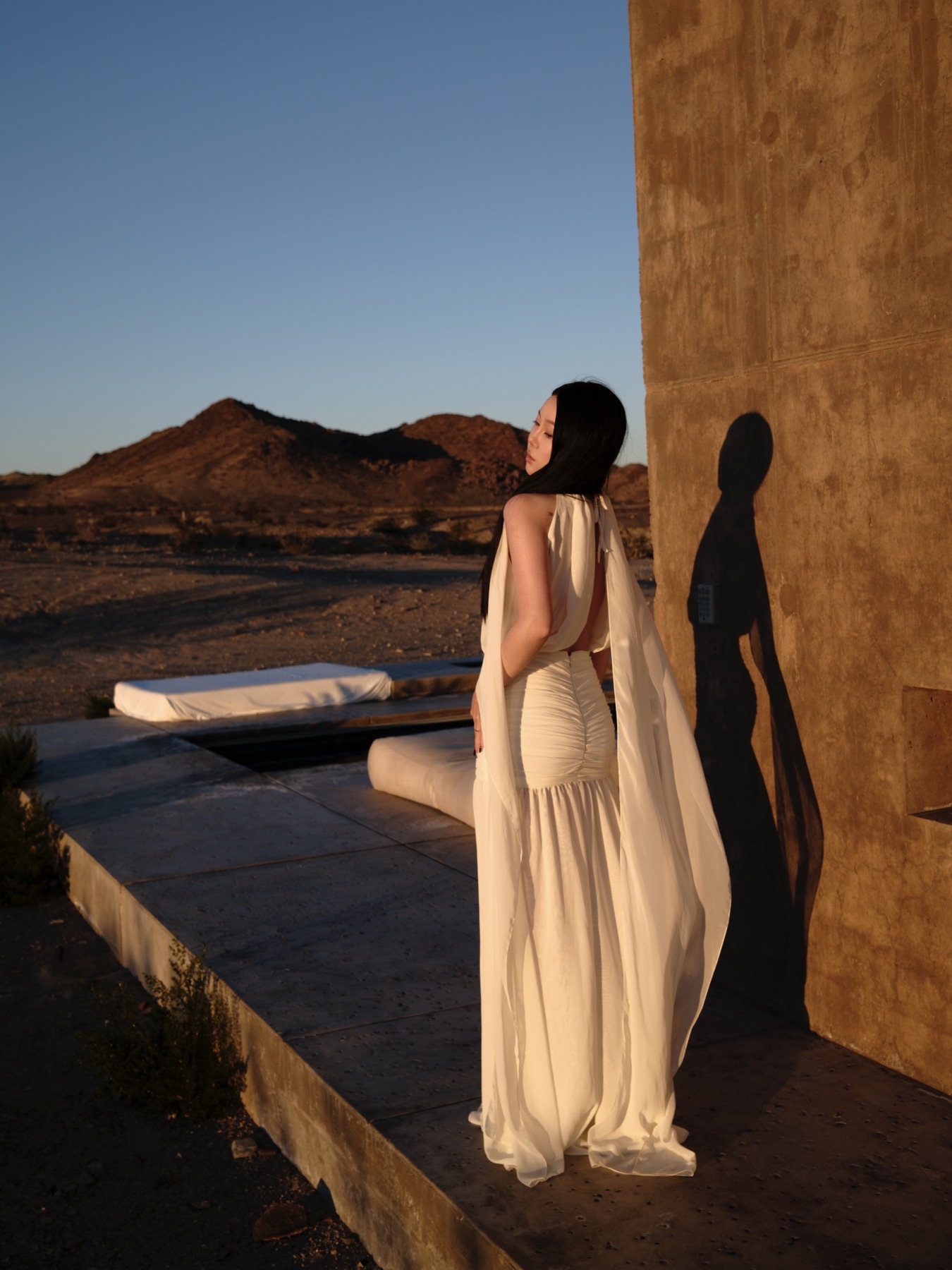 White dress moving through warm desert architecture