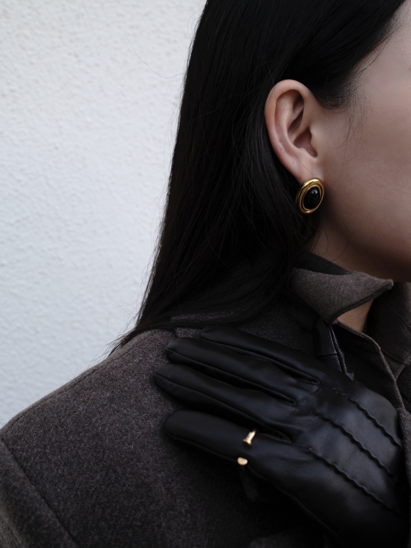 Black leather glove and gold earring detail
