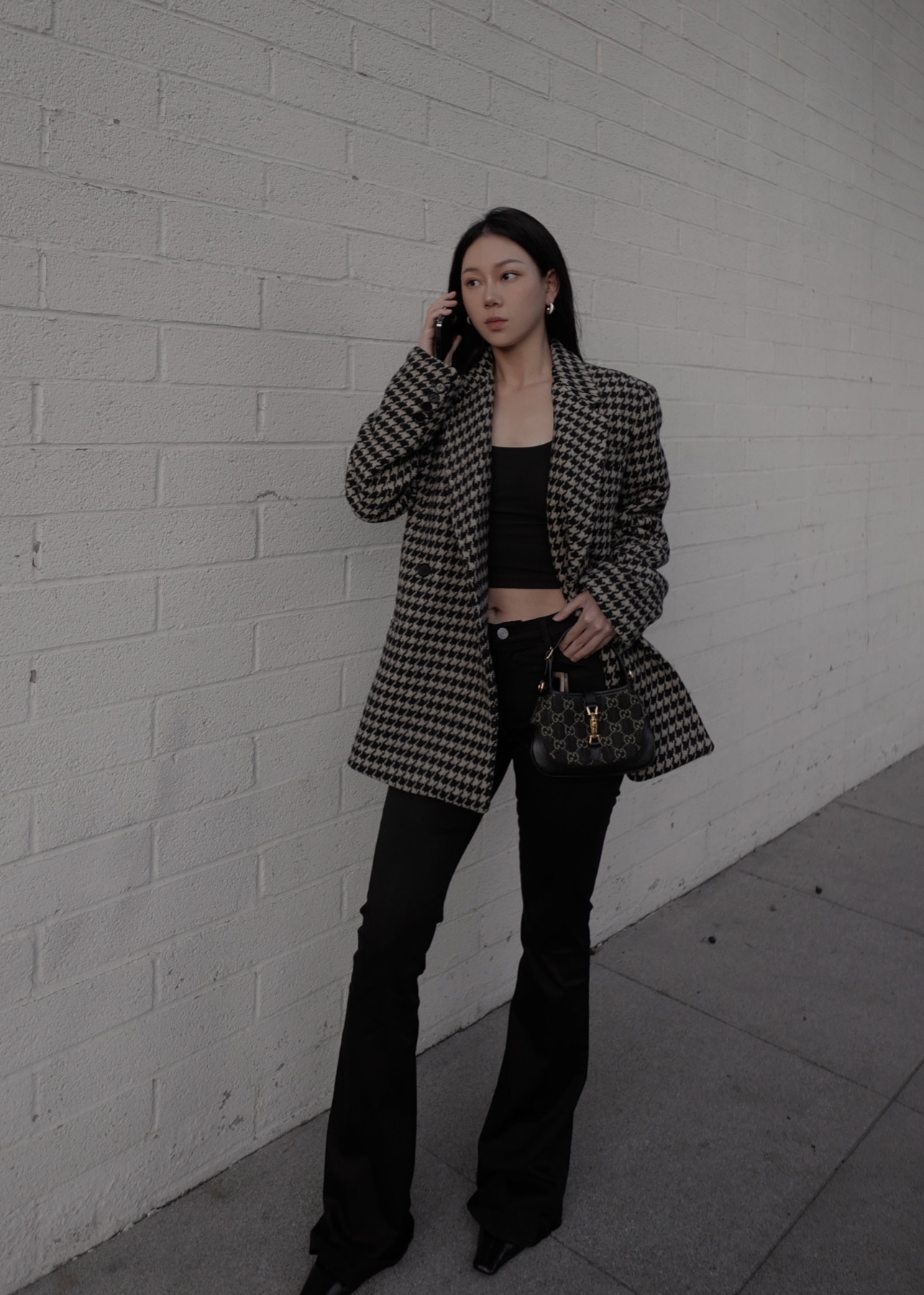 Houndstooth tailoring against a muted wall