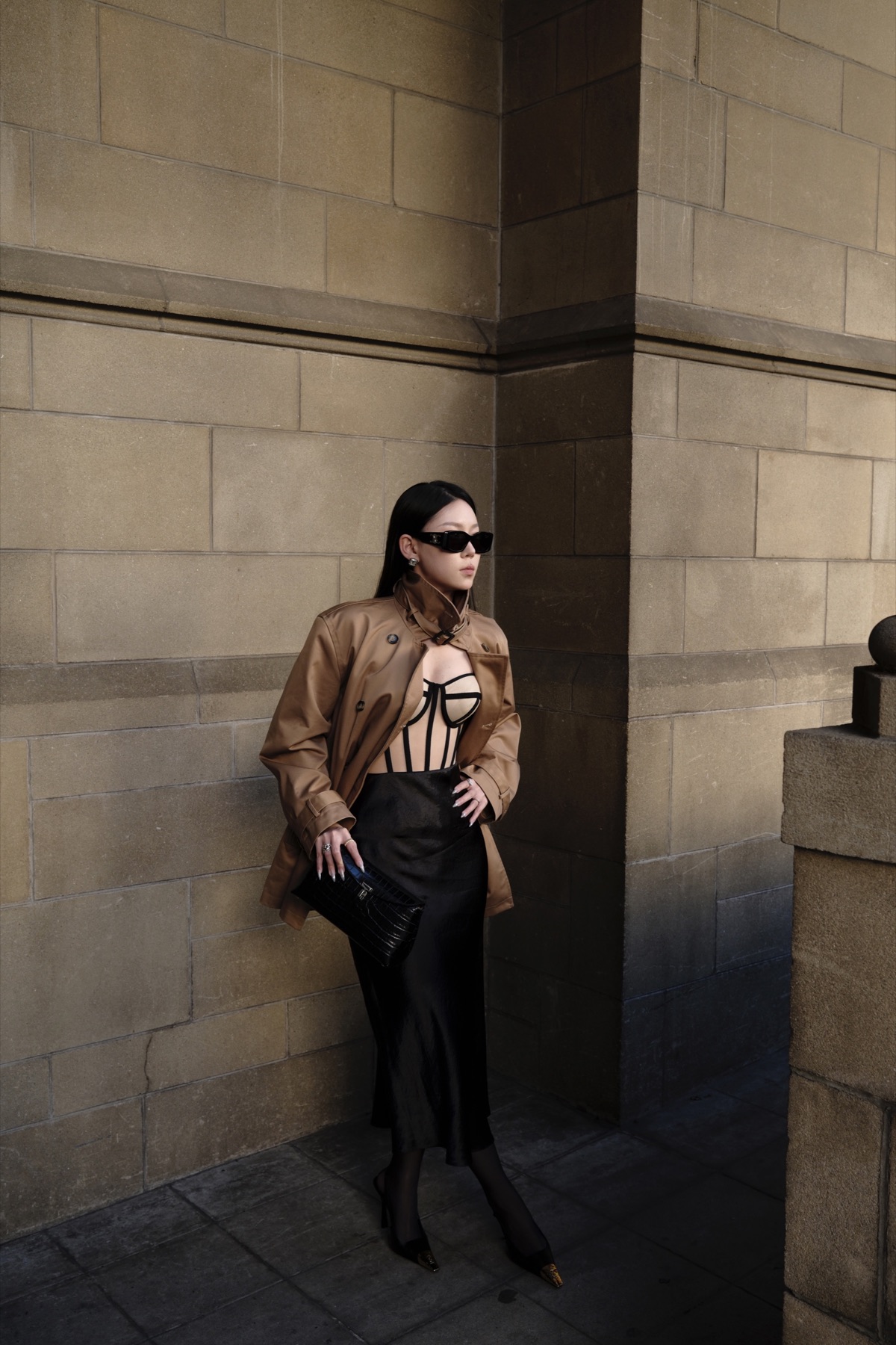 Tan leather and black dress in architectural shadow